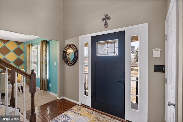 entryway featuring a wealth of natural light, stairs, baseboards, and wood finished floors