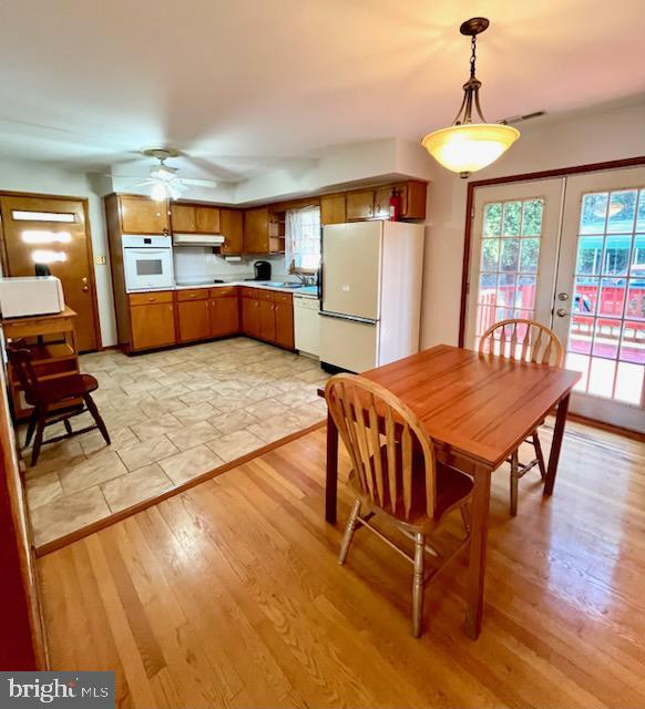 dining area featuring ceiling fan, visible vents, light wood-style flooring, and french doors