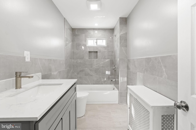 bathroom with heating unit, tile walls, toilet, and washtub / shower combination