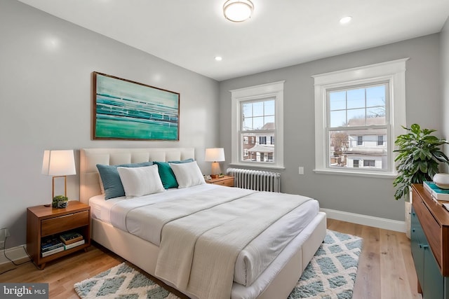 bedroom featuring light wood finished floors, recessed lighting, radiator, and baseboards