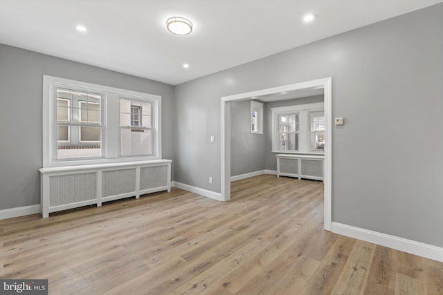 interior space featuring baseboards, wood finished floors, and radiator heating unit