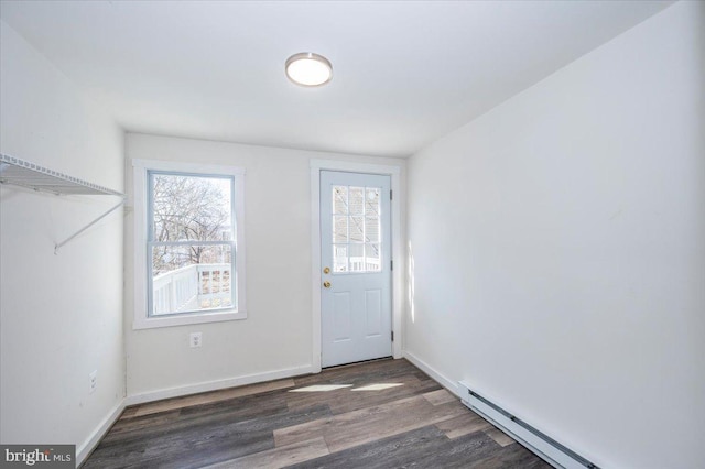 foyer entrance with baseboard heating, baseboards, and wood finished floors