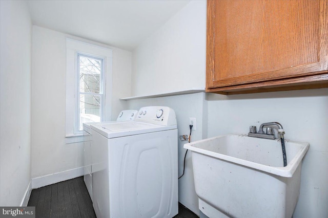 clothes washing area with a sink, dark wood-type flooring, baseboards, cabinet space, and separate washer and dryer