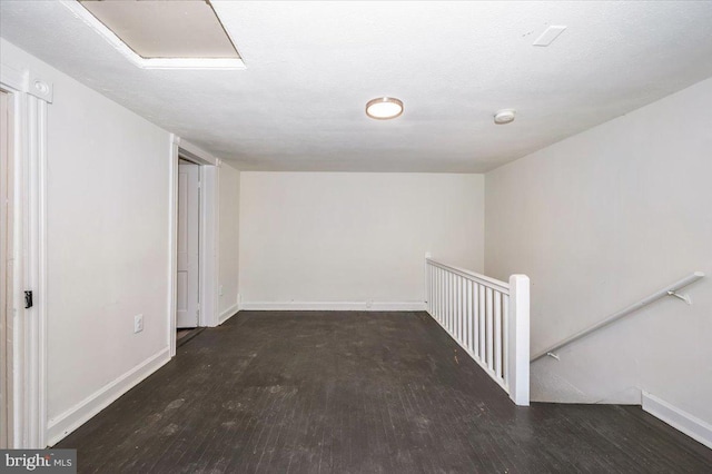 spare room featuring baseboards and wood finished floors