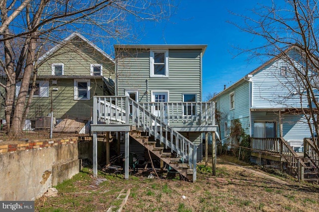 rear view of house with stairway, fence, and a wooden deck