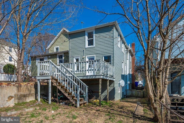 rear view of property featuring a wooden deck and stairway