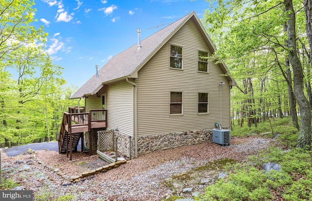 10 S Spur Ln, Hazleton, PA 18202 - rear view of house featuring a shingled roof, stairs, a deck, cooling unit, and a forest view