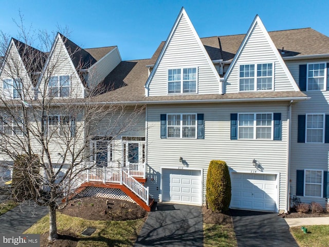 view of front of house featuring aphalt driveway, a garage, and roof with shingles