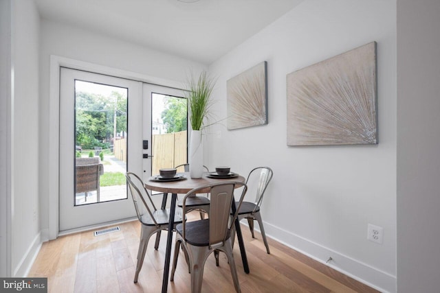 dining space with visible vents, a healthy amount of sunlight, and wood finished floors