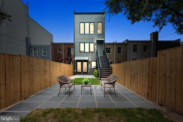 rear view of house with a patio area, stairs, and fence