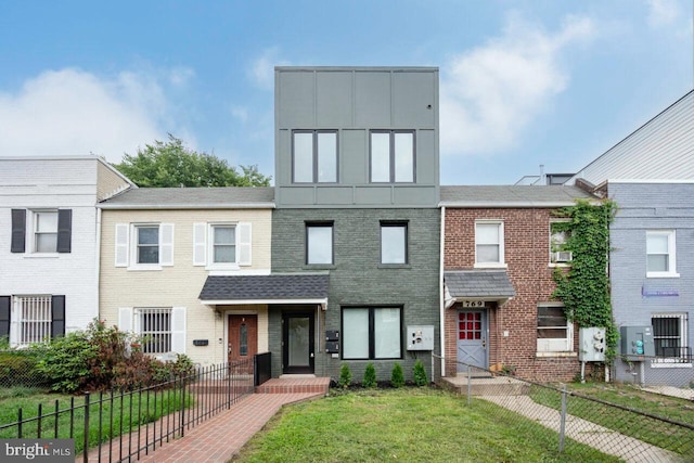 view of front of home featuring brick siding, a front yard, and fence