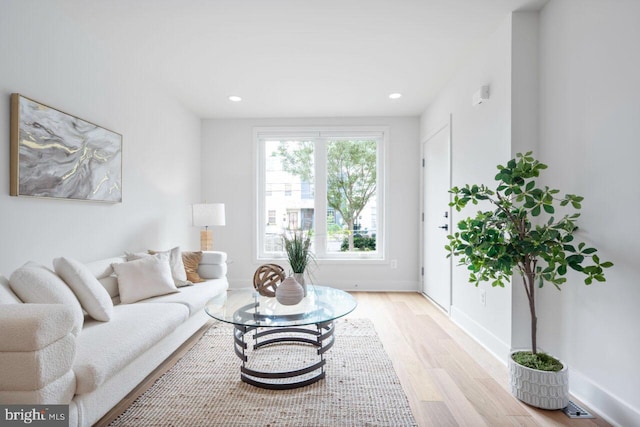 living room with recessed lighting, baseboards, and light wood-style flooring