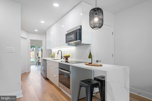 kitchen with white cabinets, stainless steel appliances, modern cabinets, and a sink