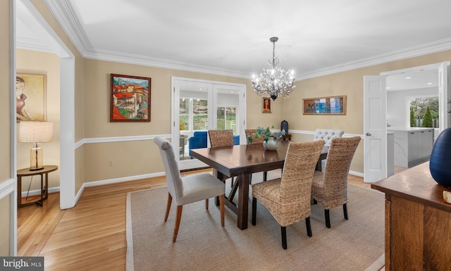 dining area featuring light wood-style floors, a wealth of natural light, and ornamental molding