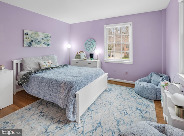 bedroom featuring baseboards and wood finished floors