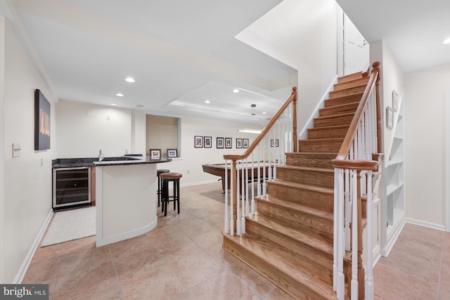 interior space with wine cooler, recessed lighting, wet bar, and baseboards