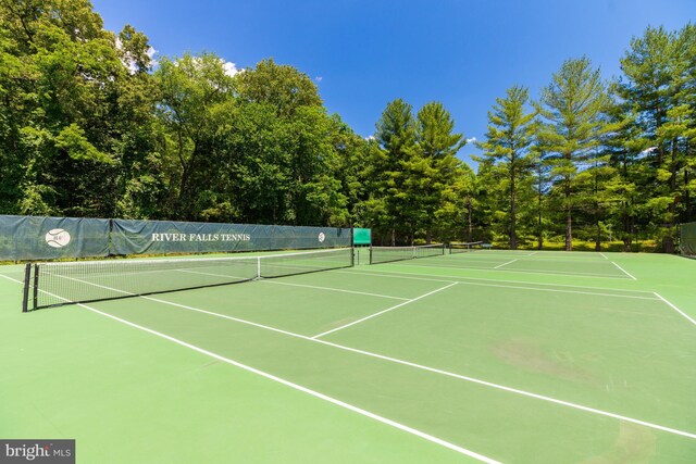 view of tennis court featuring community basketball court and fence