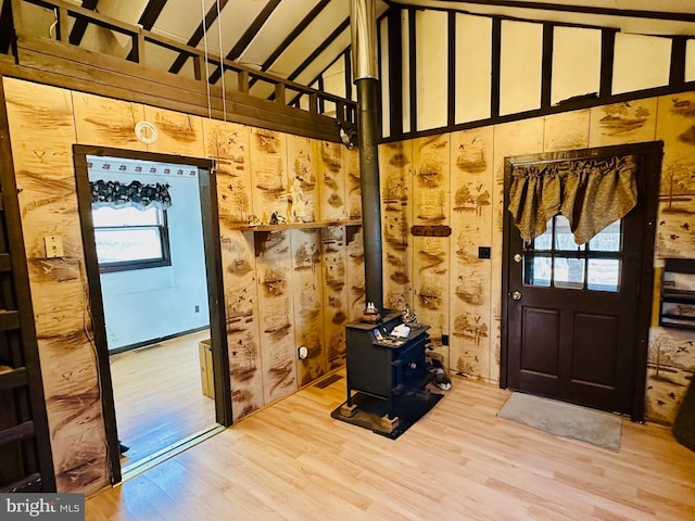 foyer featuring a wealth of natural light, a wood stove, and wood finished floors