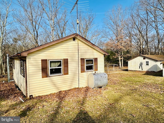 view of property exterior with a lawn and heating fuel