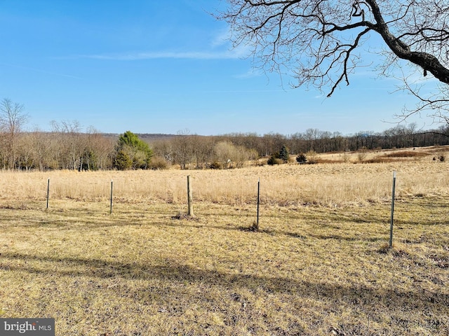 view of yard featuring a rural view and fence