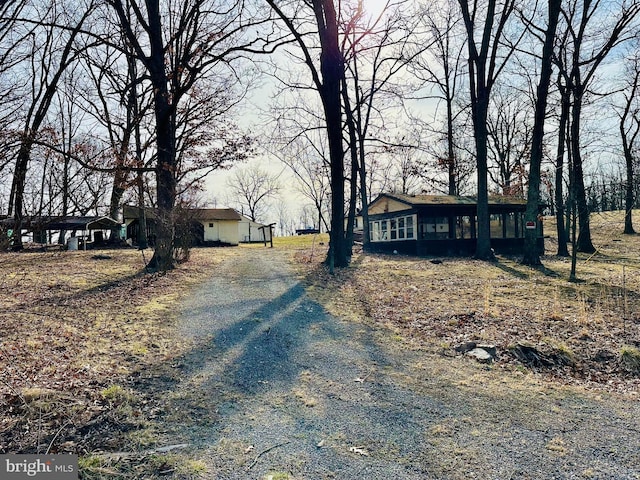 view of front of property with gravel driveway and a sunroom