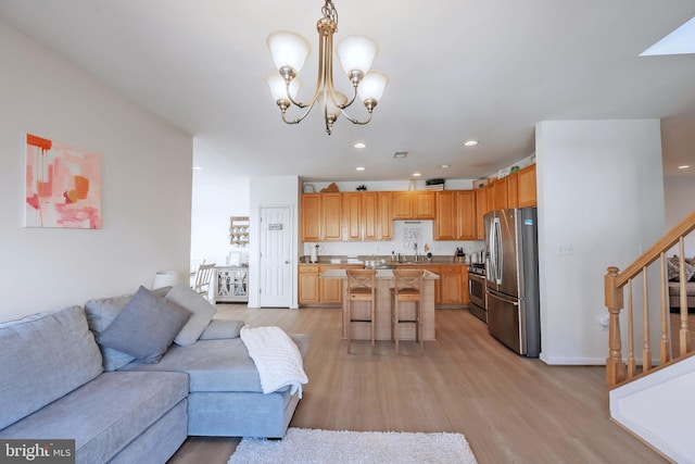 living room featuring recessed lighting, stairway, a chandelier, and light wood finished floors