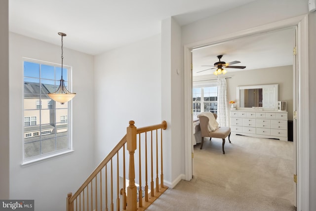 corridor featuring an upstairs landing and carpet floors