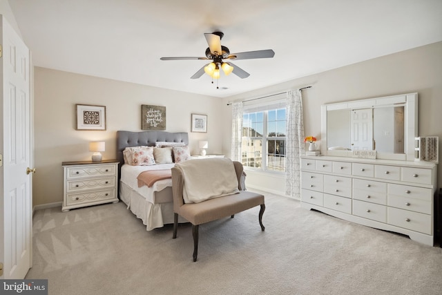 bedroom featuring baseboards, light colored carpet, and ceiling fan