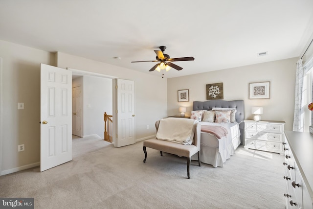 bedroom with baseboards, visible vents, and light carpet