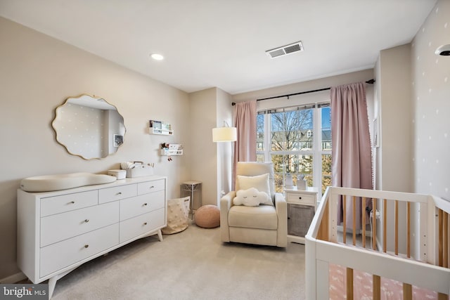 bedroom featuring a nursery area, recessed lighting, visible vents, and light carpet