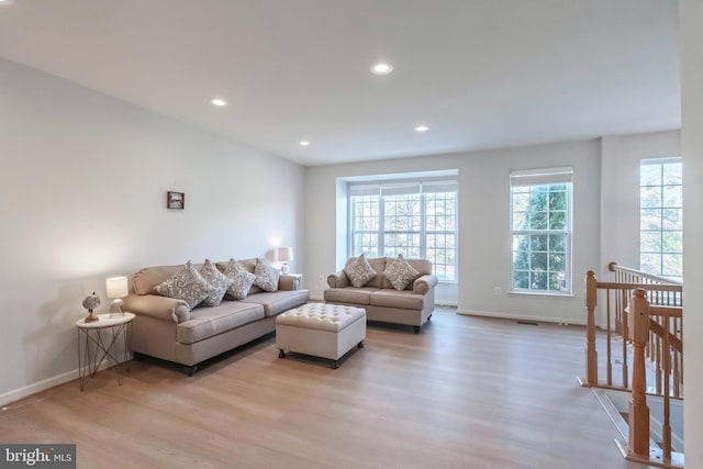 living area featuring recessed lighting, light wood-type flooring, baseboards, and a healthy amount of sunlight