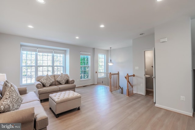 living area with light wood finished floors, recessed lighting, baseboards, and a wealth of natural light