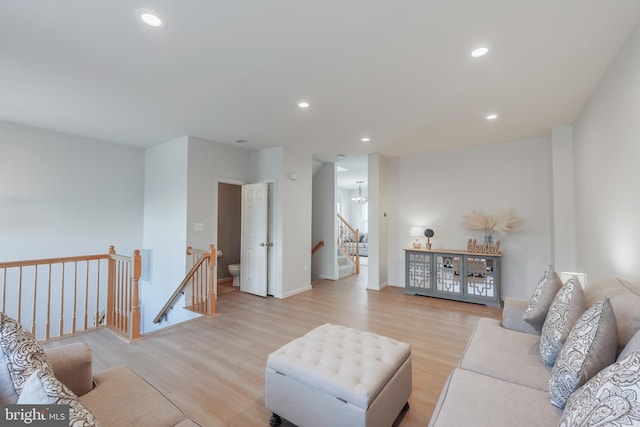 living area featuring a chandelier, recessed lighting, light wood-style flooring, and baseboards