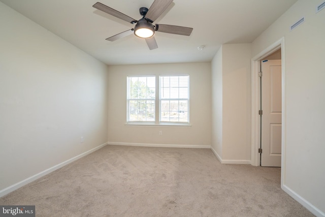 carpeted empty room featuring baseboards and ceiling fan