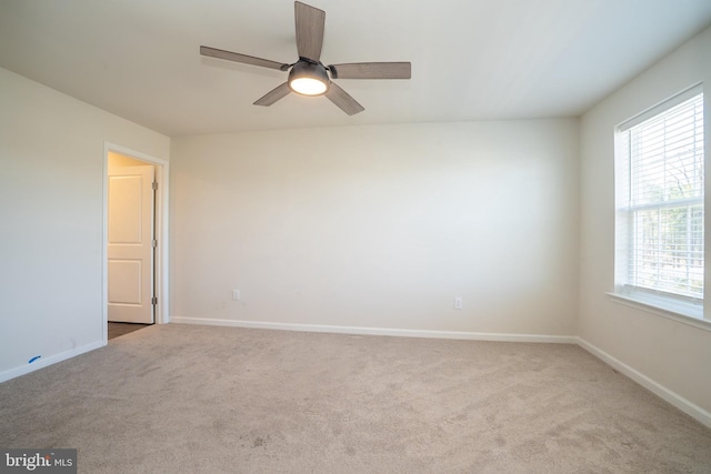 unfurnished room with carpet flooring, a ceiling fan, and baseboards