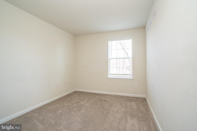 carpeted spare room with baseboards