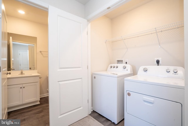 laundry area with washing machine and clothes dryer, laundry area, a sink, and dark wood-style flooring