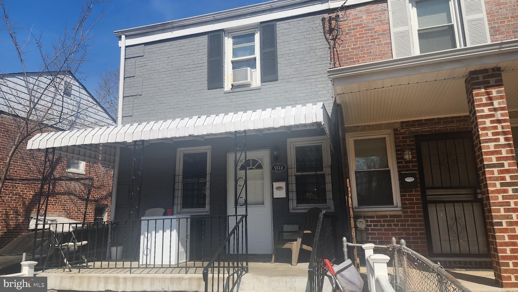 multi unit property featuring brick siding and covered porch