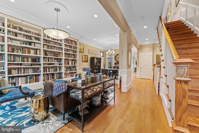 interior space featuring a wainscoted wall, light wood finished floors, recessed lighting, crown molding, and a notable chandelier