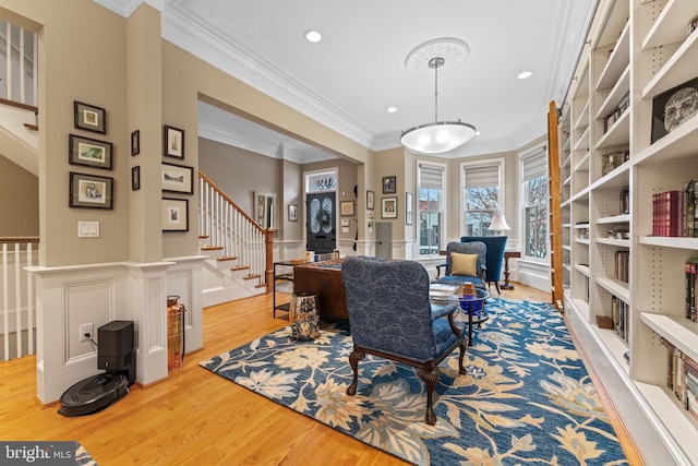 office area with a wainscoted wall, light wood-style flooring, recessed lighting, crown molding, and a decorative wall