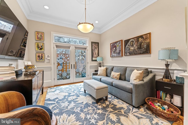 living room with a wainscoted wall, wood finished floors, recessed lighting, french doors, and crown molding