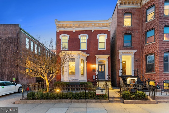 view of property featuring a fenced front yard and brick siding