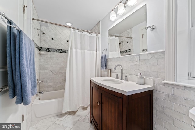 full bathroom with tasteful backsplash, tile walls, vanity, and shower / bath combo