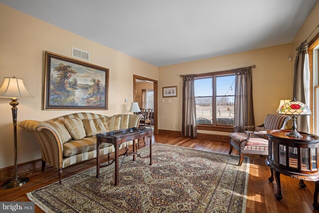 living area featuring visible vents, baseboards, and hardwood / wood-style floors