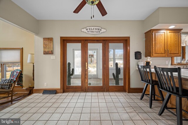 foyer featuring plenty of natural light, baseboards, and ceiling fan