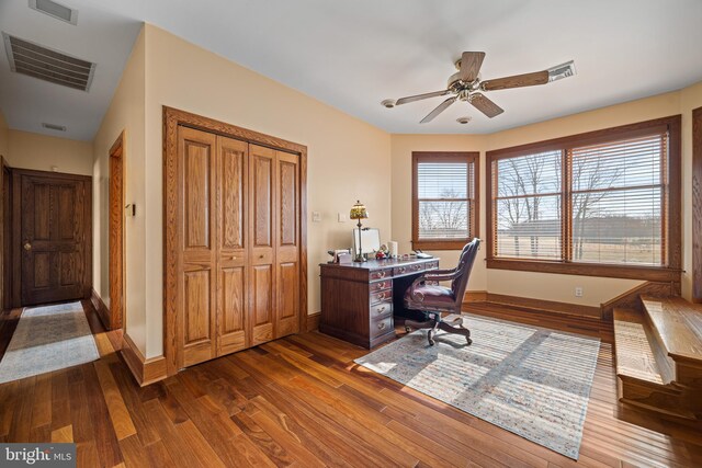 office with dark wood finished floors, a healthy amount of sunlight, visible vents, and ceiling fan