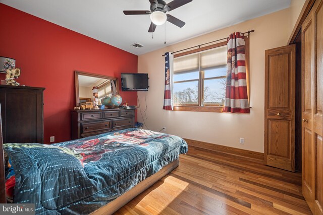 bedroom with visible vents, baseboards, and wood finished floors