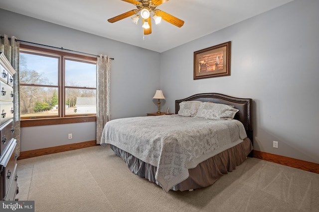 bedroom featuring baseboards, light carpet, and ceiling fan