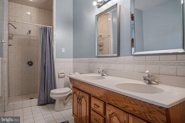 full bath featuring a tile shower, toilet, tile walls, and a sink