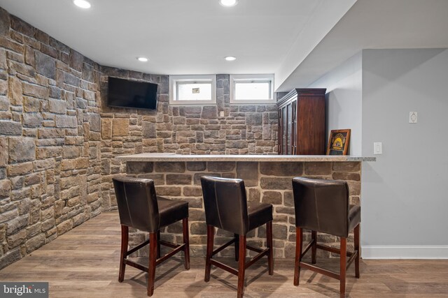 bar with a dry bar, recessed lighting, wood finished floors, and baseboards